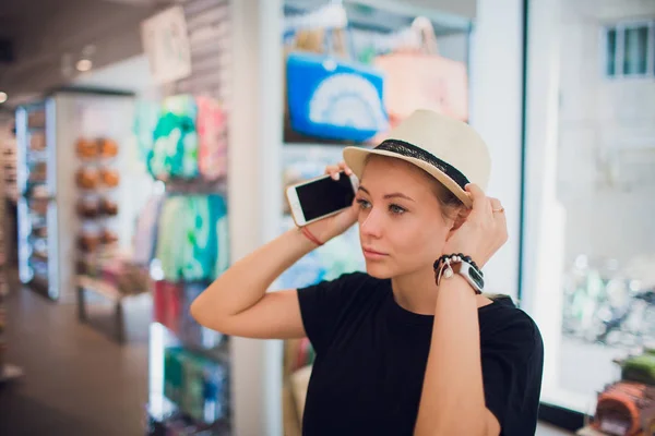 魅力的な女性は、帽子にしようとしています。幸せな夏のショッピング. — ストック写真