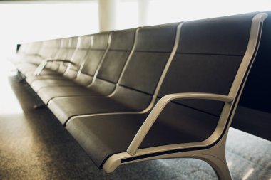 Bavul Havaalanı terminal, bekleme salonunda iki gezgin odaklanmak koltuk, tatil kavramı, arka planda güzel gün batımı.