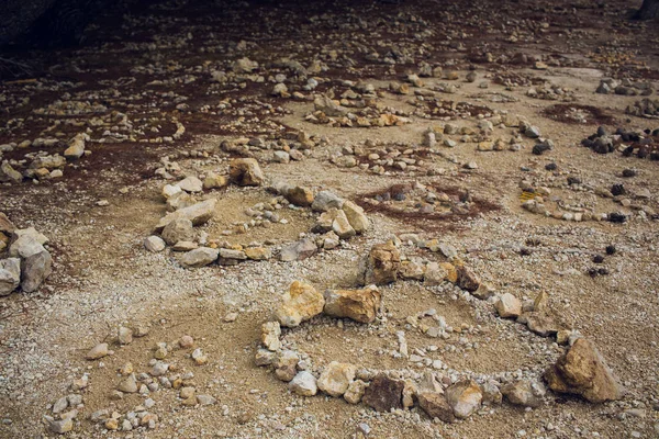 Srdce na pozadí písku, vykládané kamínky. lze použít jako pozadí. — Stock fotografie