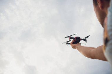 Genç holding drone uçuş doğa, önce adam. Güzel adam pilot quadrocopter açık hazır olun. kaldırdı