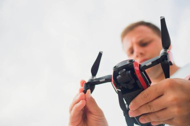 Genç holding drone uçuş doğa, önce adam. Güzel adam pilot quadrocopter açık hazırlamak.