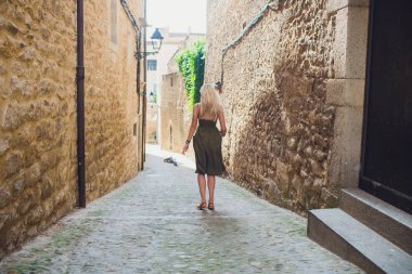 Elbiseli çekici seksi sarışın kadın kendini Avrupa Barselona sokakta yürürken sarar.