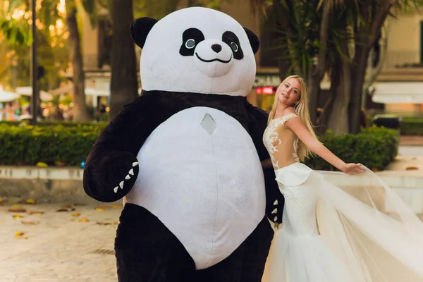 Un homme en costume de panda réconforte une femme blessée marche dans la ville — Photo