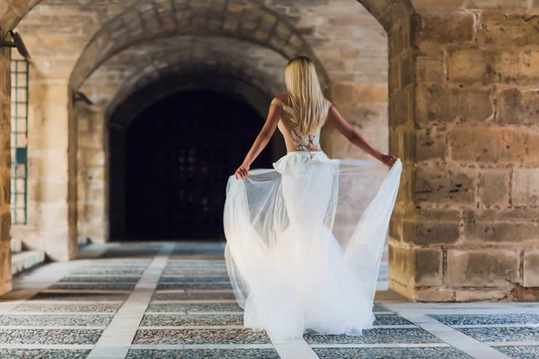 Bella ragazza, modella con i capelli lunghi in posa nel parco vicino alla grande parete . — Foto Stock