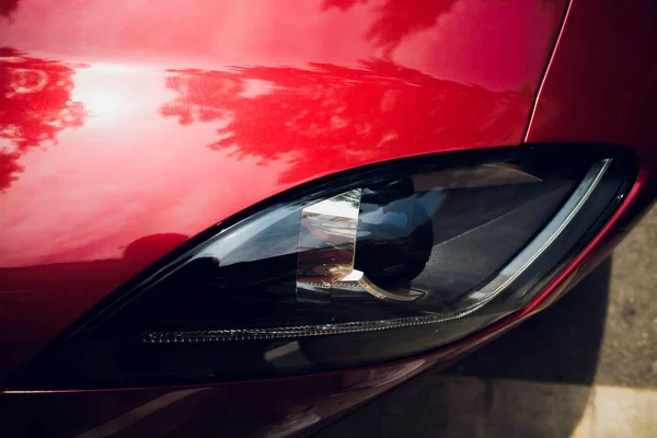 Phares et capot de voiture sport rouge avec étoiles argentées . — Photo