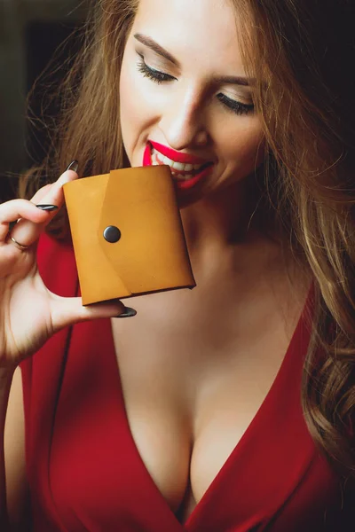 Velká prsa, výsek na šaty, červená barva oblečení, žena drží spojky nebo kabelku. — Stock fotografie