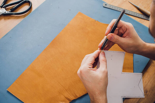 изделия из кожи ремесленника за столом в мастерской
.