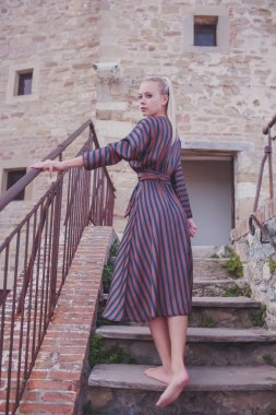 Dışarıdaki tuğla duvarın yanındaki neşeli kadının portresi..