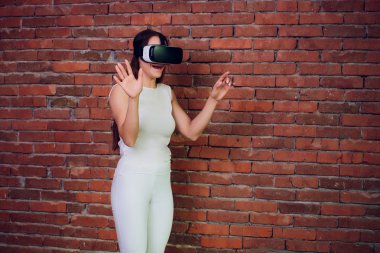 Sanal gerçeklik aygıt. Kadın sanal gerçeklik bardaklarda oyun oynama. Sanal ekran ile kulaklık. Kız dokunmatik modern gözlük ile sanal ekran kullanarak.