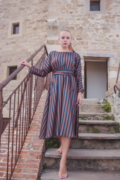 Portret van vrolijke vrouw in de buurt van de bakstenen muur buiten. — Stockfoto