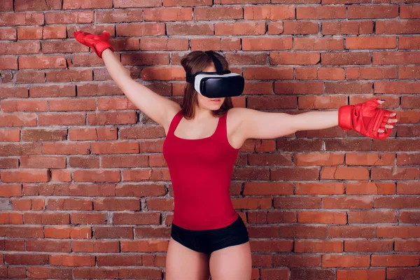 Young fighter boxer fit girl in VR glasses wearing boxing gloves in training