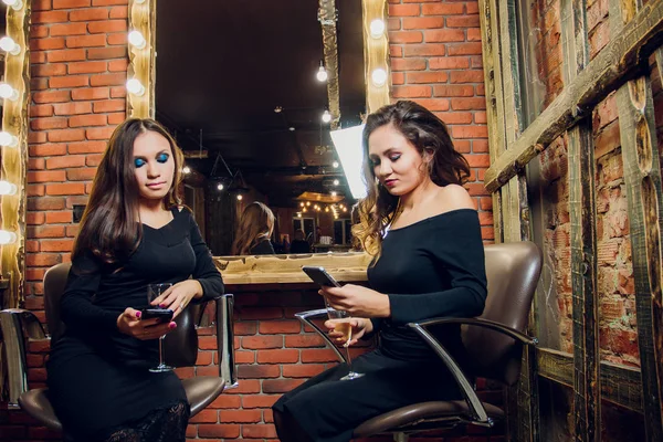 Dois bela jovem mulher lá fora em um café da cidade rindo e bebendo champanhe . — Fotografia de Stock