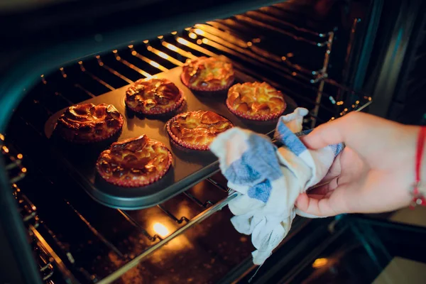 Mujer hornear cupcakes en la mano del horno . — Foto de Stock