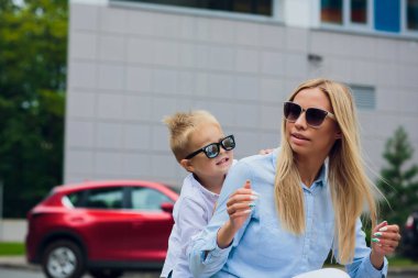 Genç Anne ile küçük oğlu açık havada. Cam duvara