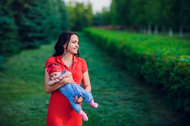 3 aylık çocuk açık havada mommys elinde. Yeni doğmuş bir bebek için ilk yürüyüş