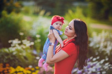 3 aylık çocuk açık havada mommys elinde. Yeni doğmuş bir bebek için ilk yürüyüş