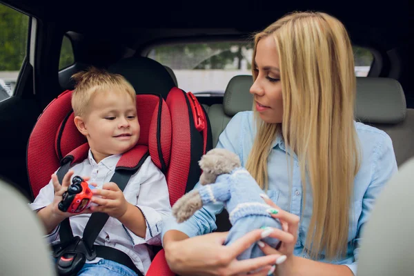 Mother worried about her childrens safety in a car Son near mom Babes sitting inside modern auto People look camera The idea of safe traffic — Stock Photo, Image