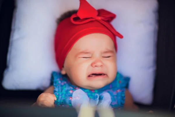 3 month old baby in wheelchair on the street is crying