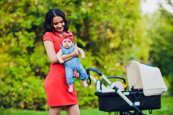 Moeder met baby pram wandelwagen, vervoer in de stad wandelen. Liefde en familie concept. — Stockfoto