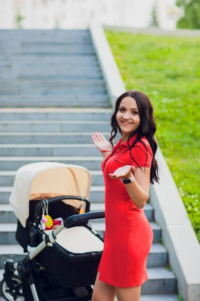 woman can not lift a stroller up. modern baby stroller. stairs without a lifting frame for wheelchairs for children and disabled people. a difficult situation. not a comfortable city