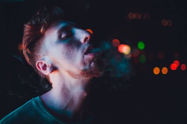 Geceleri sokaklarda portre olgun adam sigara elektronik sigara