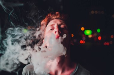 Geceleri sokaklarda portre olgun adam sigara elektronik sigara