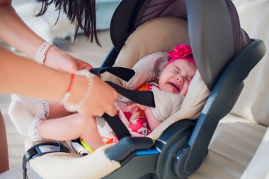 Aile, ulaşım, güvenlik, araba gezisi ve insanlar kavramı - mutlu anne kız bebek evde bebek koltuğu sabitleme