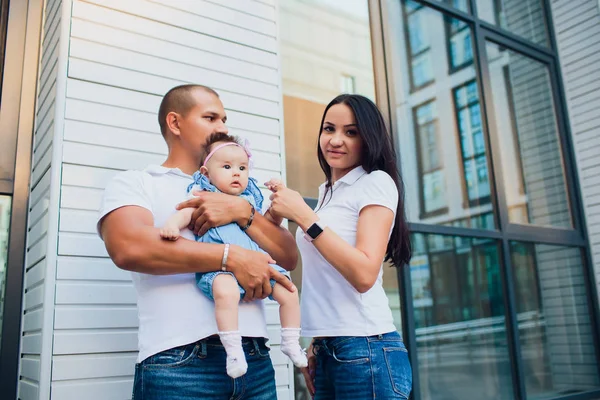 Echtpaar, aman bedrijf kind, vrouw met man op zijn schouders. tegen de achtergrond glazen gebouw — Stockfoto