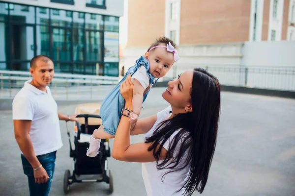 Gehuwd paar, een vrouw houdt een baby terwijl de vader kijkt naar de bodem en houdt van een kinderwagen — Stockfoto