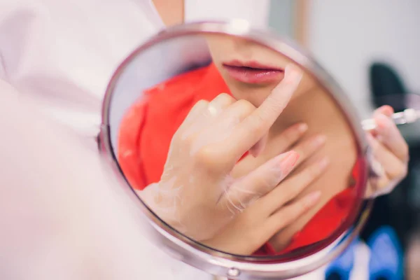 Jonge vrouw krijgt een injectie in haar lippen in de schoonheidssalon. Schoonheid injecties-vrouw liggend in het kantoor van schoonheidsspecialiste. Lippen met hyaluronzuur, contouren, procedure, revitalisatie verhogen — Stockfoto