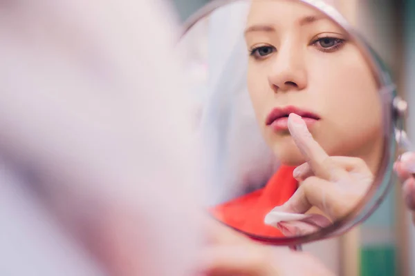 Junge Frau bekommt im Schönheitssalon eine Spritze in die Lippen. Schönheitsinjektionen - Frau liegt im Kosmetikbüro. Steigerung der Lippen durch Hyaluronsäure, Umformung, Revitalisierung — Stockfoto