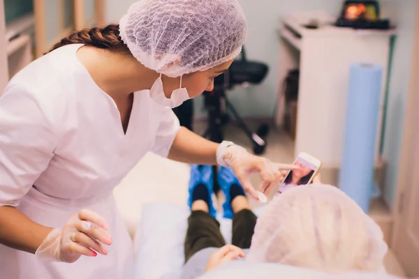 Wanita muda mendapatkan suntikan di dalam salonnya Lips in Beauty. Kecantikan Injeksi-Perempuan berbaring di kantor kecantikan. Naikkan Bibir dengan asam Hyaluronat, Kontur prosedur, revitalisasi — Stok Foto