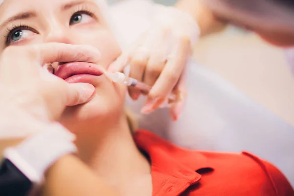 Wanita muda mendapatkan suntikan di dalam salonnya Lips in Beauty. Kecantikan Injeksi-Perempuan berbaring di kantor kecantikan. Naikkan Bibir dengan asam Hyaluronat, Kontur prosedur, revitalisasi — Stok Foto