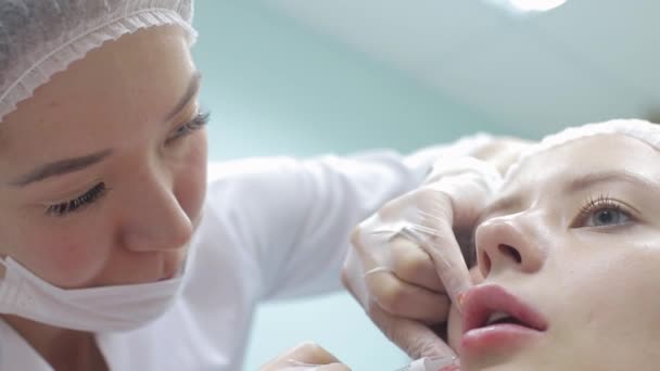 Cosmetologist fazer a injeção nos lábios das mulheres. aumento labial e cirurgia plástica . — Vídeo de Stock