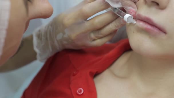 Kosmetikerin macht Injektion in die Lippen der Frauen. Lippenvergrößerung und plastische Chirurgie. — Stockvideo