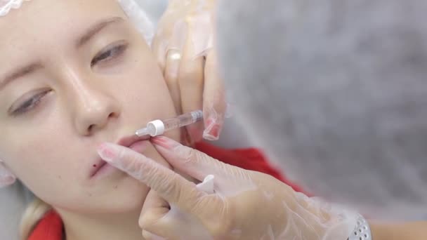 Schoonheidsspecialist maken injectie in de lippen van de dames. lipvergroting en plastische chirurgie. — Stockvideo