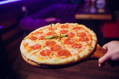 garson ile lezzetli sıcak pizza tepsisi taşıyabilir. İtalyan mutfağı.