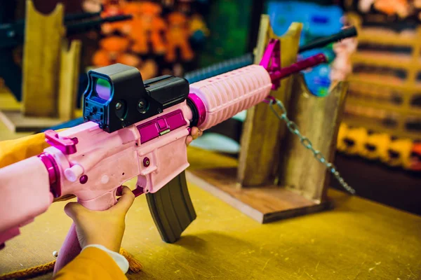 child firing hand pink gun an indoor gun range