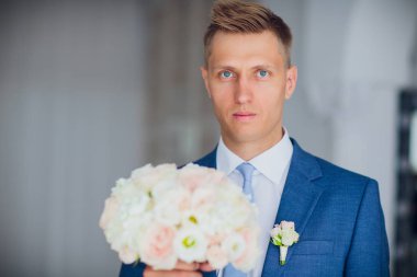 Şık damat holding modern düğün buket ihale pembe gül ve okaliptüs. Düğün hazırlıkları ve dekor.