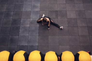 Üstten görünüm bir uyum ve streching yaparken sportif kız bacaklar için egzersiz. Genç kadının spor salonunda, sicim yapması ince Stadyumu. Kapalı.
