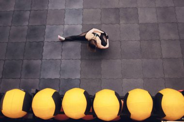 Üstten görünüm bir uyum ve streching yaparken sportif kız bacaklar için egzersiz. Genç kadının spor salonunda, sicim yapması ince Stadyumu. Kapalı.