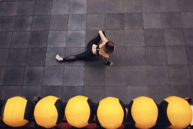 Üstten görünüm bir uyum ve streching yaparken sportif kız bacaklar için egzersiz. Genç kadının spor salonunda, sicim yapması ince Stadyumu. Kapalı.