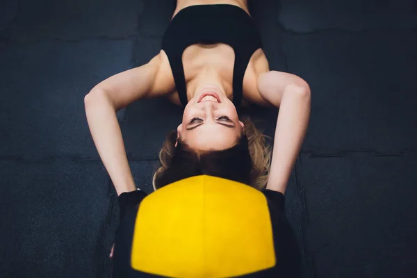 Modelo de fitness feminino exercitando-se com bola de medicina no ginásio. Jovem fazendo exercício usando bola de fitness . — Fotografia de Stock