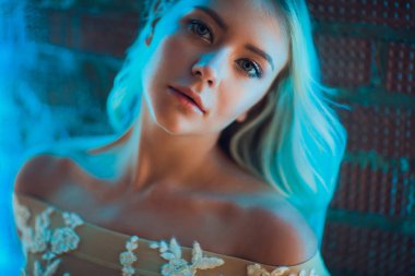 Pencerenin önünde poz çok güzel sarışın kadın uzun saçlı çıplak omuz ile elbise.