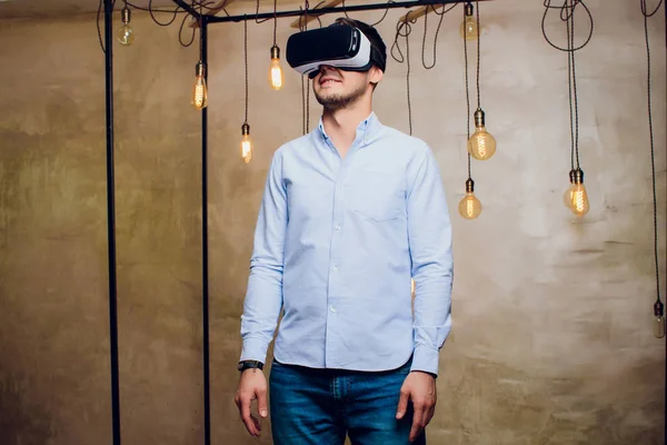 Amazed man looking in a VR goggles and gesturing.