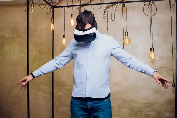 Amazed man looking in a VR goggles and gesturing.