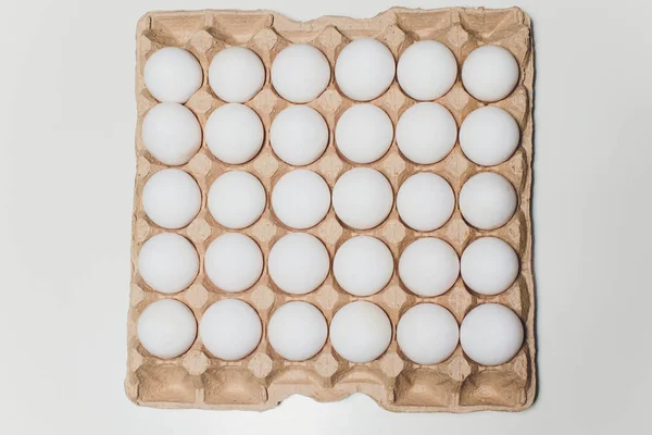 Several white eggs in an egg carton.