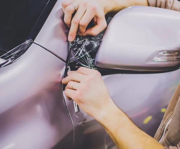 Auto avvolgente specialista mettendo foglio di vinile o film su auto tagliato con coltello — Foto Stock