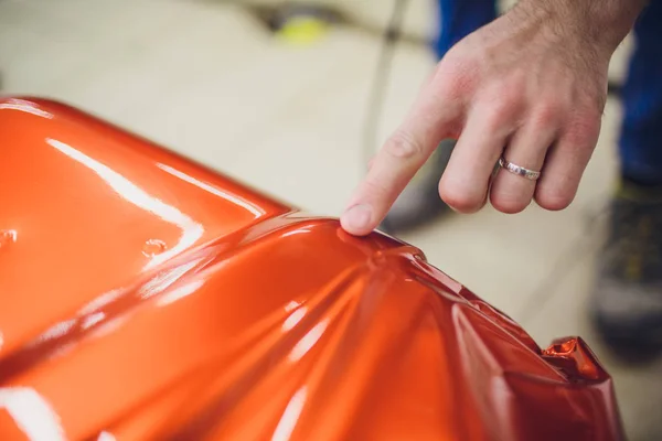 Especialista en envoltura de automóviles poniendo papel de vinilo o película de envoltura de automóviles película protectora yate, barco, barco, coche, casa móvil. calentamiento de película naranja con secador de pelo y recorte de plástico suave escobilla dura —  Fotos de Stock