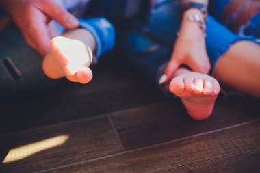 Küçük bebek ayaklar holding yetişkin ebeveyn eller